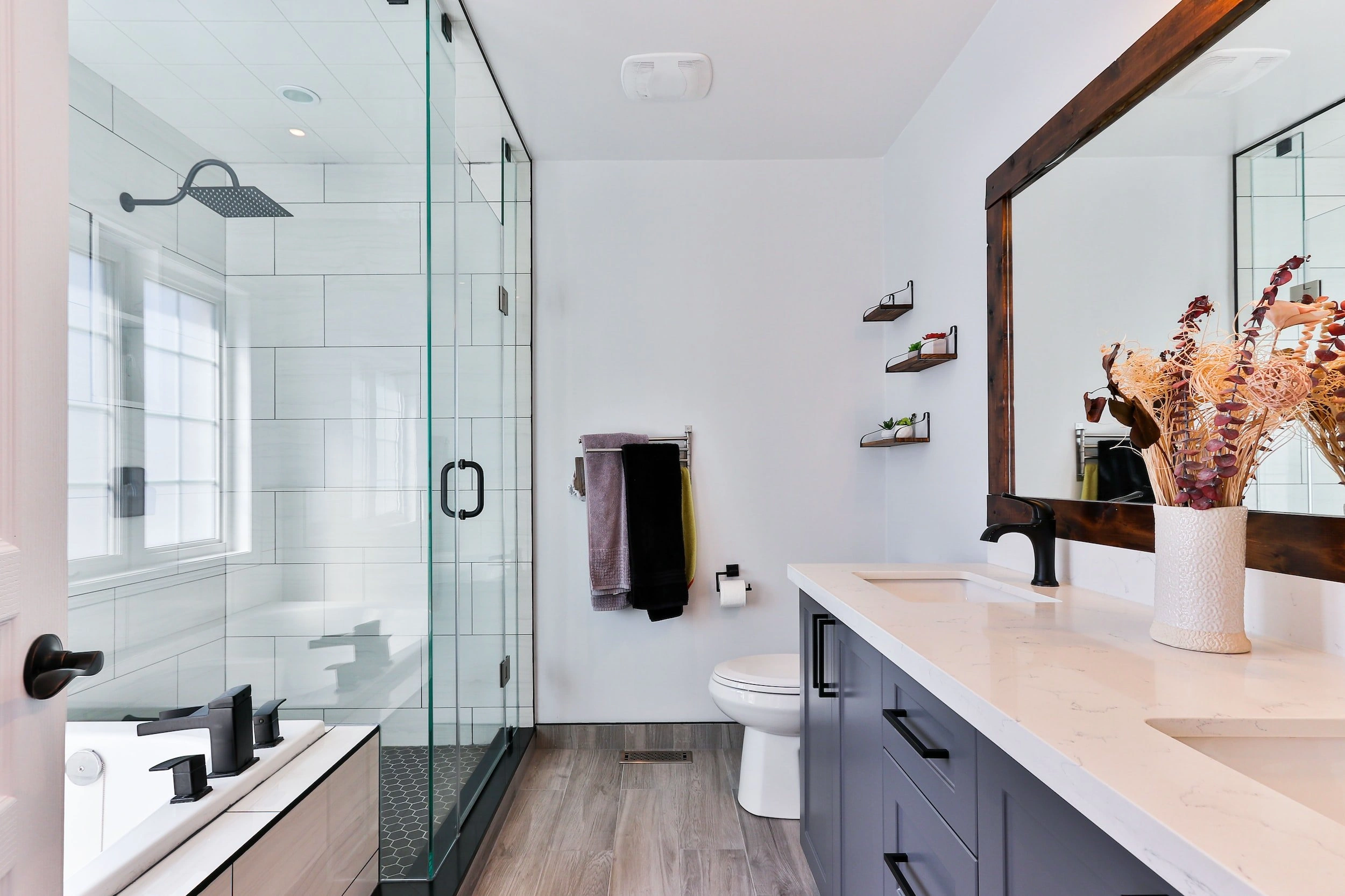 Bathroom remodeling services featuring a floating vanity and walk-in shower in a modern Southwest Florida home.