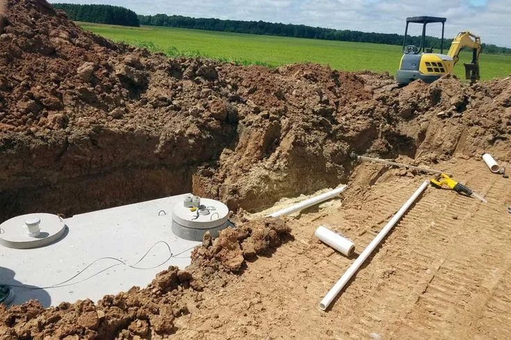 Excavator digging a trench as part of septic system services for new tank installation in a Florida backyard